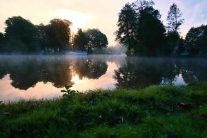 een zonsopgang bij zonsopgang, met mist op de rivier en warme lichtatmosfeer. landschapsopname foto