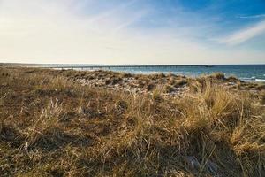 op het strand van de Oostzee met wolken, duinen en strand. wandelen in het voorjaar. foto