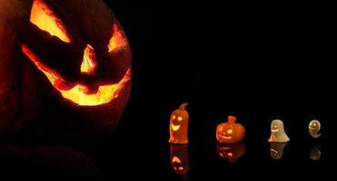 Halloween-pompoen met brandende kaarsen op zwarte achtergrond foto