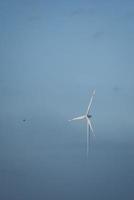 windmolen in mistig landschap. hernieuwbare energie voor een milieubewuste toekomst foto