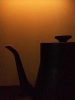silhouetfoto van een theepot op een gele tot gouden achtergrond foto