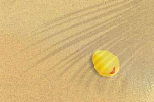 top-up weergave van gele rubberen eend op zandstrand. vakantie concept achtergrond. foto