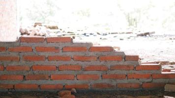 oude bakstenen muur heeft bruine vlekken en krassen. verlaten architectuur is iets verschrikkelijks. foto