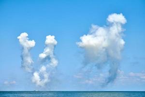 witte koolstofvezelwolken in de blauwe lucht die zeevernietigers verbergen voor anti-scheepsraketten, militaire show foto