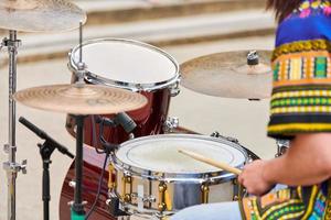 drummer man drummen percussie met stokken, drumstel op concertpodium, drumsticks en drums foto