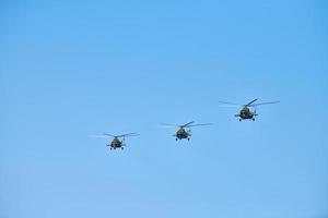 drie militaire helikopters die in de blauwe lucht vliegen en demonstratievlucht uitvoeren, luchtshow, kopieerruimte foto