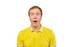verraste jonge man met grappige gezichtsuitdrukking in geel t-shirt, witte geïsoleerde achtergrond foto