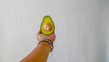 de helft van de avocado in de linkerhand. foto