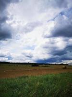 een close up van een groen veld met wolken in de lucht foto