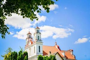 st. Jacob de apostelkerk in Kurtuvenai-stad, met de achtergrond van het plattelandspanorama van Litouwen foto