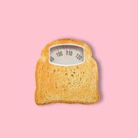 gesneden toastbrood als weegschaal op roze achtergrond. dieet concept. bovenaanzicht. minimaal voedselconcept. collage gemaakt van toast en weegschaal. hedendaagse kunstcollage. foto