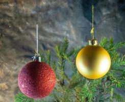 rode en gouden kerstballen op de achtergrond van dennentakken. kerst decoratie foto