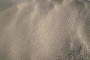 zand textuur. golvende zand gestructureerde achtergrond. zand getextureerd strand foto