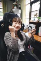 gelukkige aziatische tienervrouw blijf thuis en speel online een spel. foto