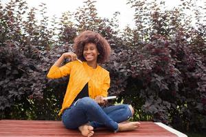 een gelukkige en jonge Afro-Amerikaanse student in het park foto