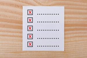 papieren notitieboekje met checklist op houten achtergrond foto