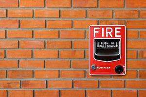 brandalarm schakelaar op bakstenen muur textuur achtergrond foto