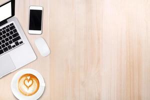 bovenaanzicht laptop of notebook, mobiele telefoon en kopje latte art koffie op houten tafel mobiele telefoon en kopje latte art koffie op houten tafel foto