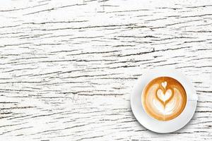 bovenaanzicht latte art koffie op wit hout foto