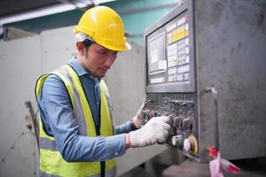 portret van een professionele ingenieur in de zware industrie met uniform, bril en helm in een staalfabriek. industriële specialist die zich in metaalconstructiefaciliteit bevindt. foto