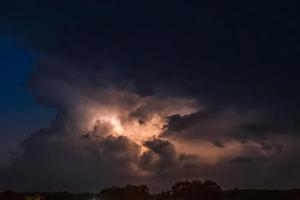 bliksemflits op een zwaar bewolkte achtergrond die donderslagen brengt foto