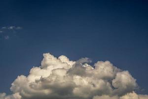 blauwe hemelachtergrond met grote witte kleine stratus cirrus gestreepte wolken foto