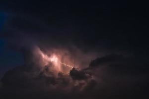 bliksemflits op een zwaar bewolkte achtergrond die donderslagen brengt foto