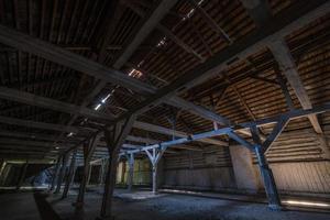 binnen donkere verlaten verwoeste houten rottende hangar met rottende kolommen foto