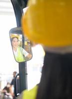 vrouwelijke werknemer die een vorkheftruck bestuurt die goederen in het magazijn verplaatst en heftruckbediening beoefent foto