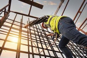 professionele bouwvakkers dragen veiligheidsharnassen en veiligheidskabels die in de bouwsteiger van het ziekenhuis werken. foto