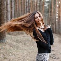 mooi meisje met lang haar wandelen in het park. lang haar wappert in de wind foto