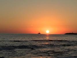 zonsondergang zee met boot foto