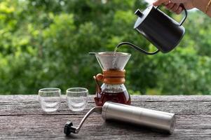 druppel koffie met apparatuur op houten tafel foto