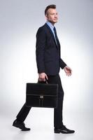 zakenman loopt met koffer in de hand foto