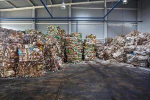 plastic geperste balen in het magazijn van afgewerkte producten op een modern afvalverwerkingsbedrijf. gescheiden afvalinzameling. recycling en opslag van afval voor verdere verwijdering. foto