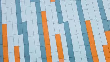 gevel van modern gebouw geconfronteerd met glooiende oranje blauwe en grijze sandwich kleurrijke panelen. architecturale achtergrond. foto
