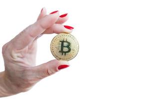 virtuele geld gouden bitcoin vrouwen hand met rode nagels vingers geïsoleerd op een witte achtergrond foto