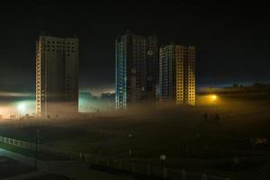 nachtpanorama van woonwijk met hoogbouw in de mist vroeg in de ochtend foto