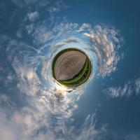 kleine kleine planeet. sferische luchtfoto 360 panorama op onverharde weg tussen velden in zomeravond zonsondergang met geweldige wolken foto