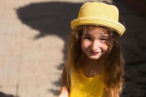 close-up van een zomerportret van een meisje in een gele hoed en zomerjurk. zonnige zomertijd, vrijheid, foto