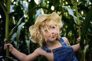 klein blond meisje dat op het platteland speelt foto