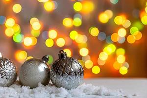 abstracte advent kerstmis achtergrond. winterversieringen ornamenten ballen op achtergrond met sneeuw en intreepupil garland lichten. vrolijk kersttijdconcept.