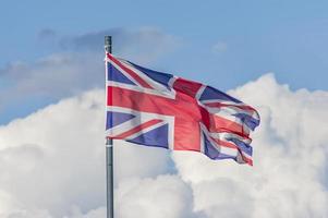 de nationale vlag van het verenigd koninkrijk wappert over de blauwe lucht foto