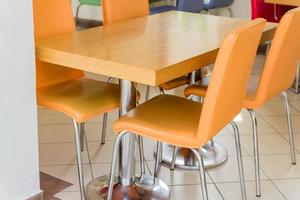 houten tafel en oranje leren stoelen - café-interieur foto