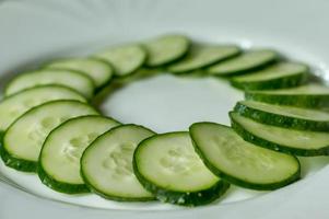 meerdere gesneden komkommers op een witte plaat foto