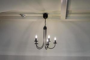 vintage kroonluchter hangend onder wit plafond met stucwerk lijstwerk foto