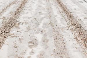 rijbaan bedekt met sneeuw en wielen sporen foto