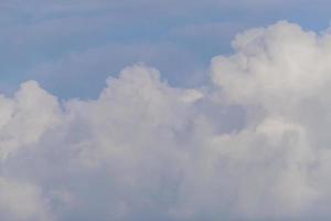 blauwe lucht met witte pluizige wolkenachtergrond foto