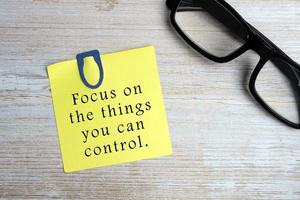 motiverende citaat op kleverige gele notitie - focus op de dingen die je kunt controleren. foto