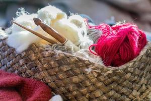 breigarenballen en -naalden in mand op een tafel foto